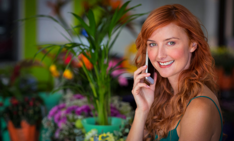 junges maedchen mit roten haaren am telefon zur beratung von kunden